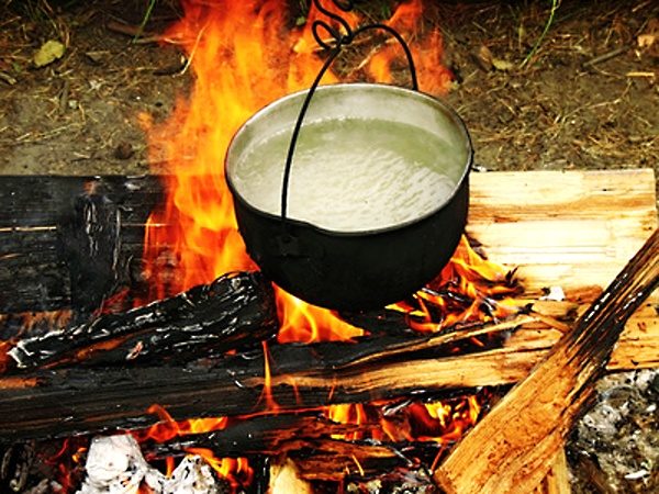 Kotlík nad ohněm s horkou vodou na polévku